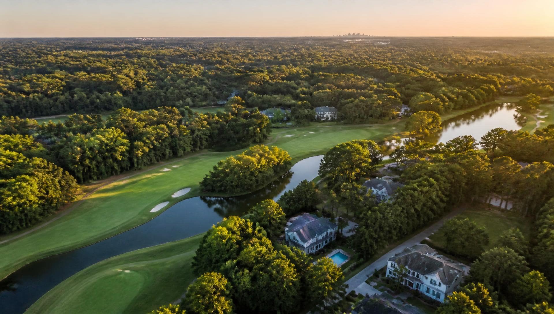 Aerial golden-hour view of Piper Glen's championship golf course and estate homes in South Charlotte