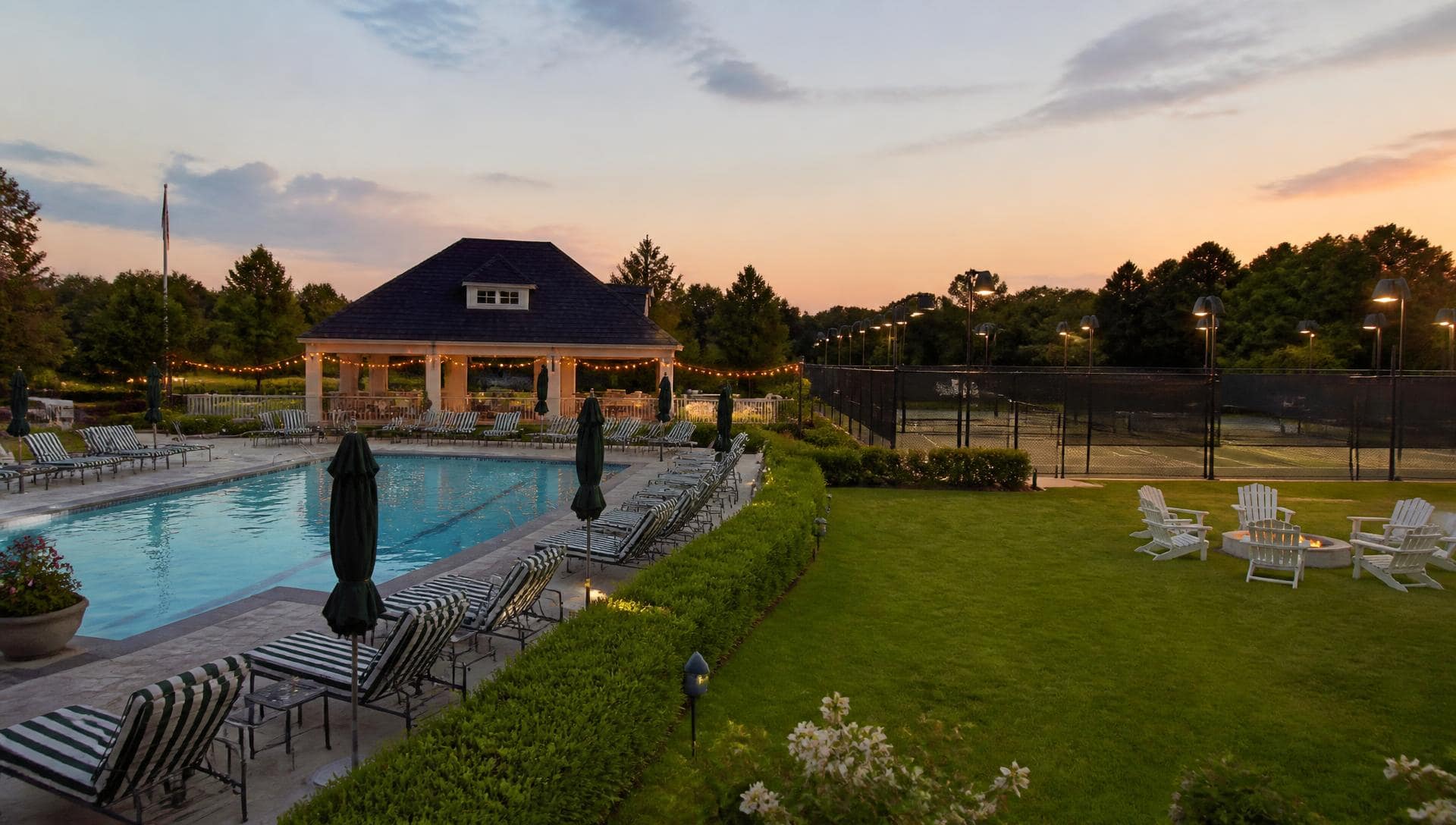 An outdoor living pavilion overlooking the golf course at dusk